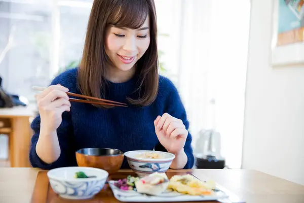young asian woman in japanese restaurant having breakfast