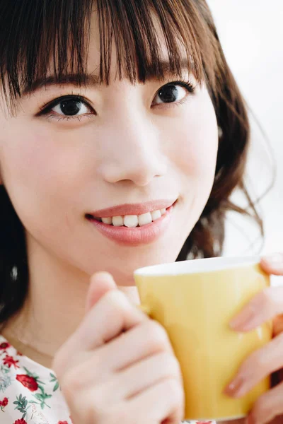 Bir fincan çay tutan kadın.