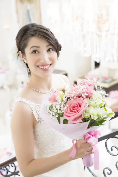 beautiful asian bride with bouquet of flowers