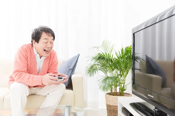 Oyun oynayan genç, mutlu Asyalı adam. 