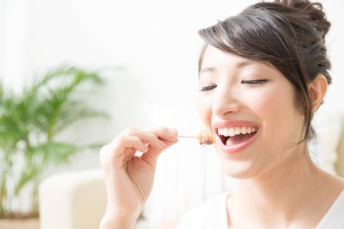 Pasta yiyen Asyalı genç ve güzel bir kadın. 