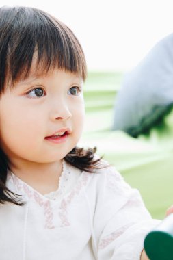 Evdeki oturma odasında oynayan tatlı Asyalı küçük kız.