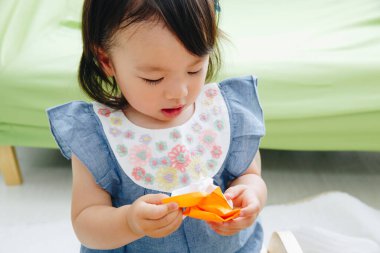 Evde oynayan Asyalı çocuk.