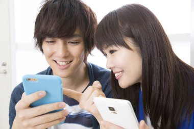 Genç çift cep telefonu kullanıyor, oyun oynuyor. 