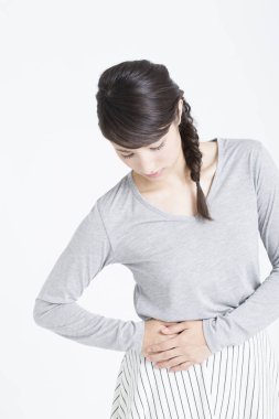 Yan tarafında acı çeken genç Asyalı kadın, stüdyo çekimi. 