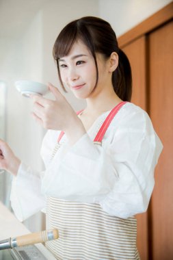 Güzel Asyalı kadın mutfakta yemek yapıyor.