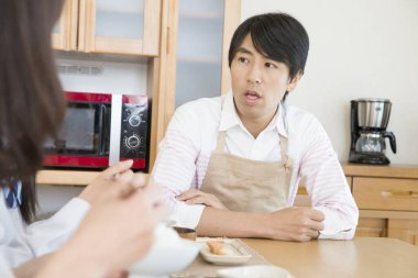 Genç çift mutfakta yemek yiyor.