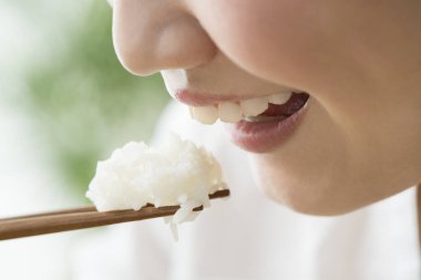 Kadın yemek çubuğuyla pilav yiyor, yakın çekim. 