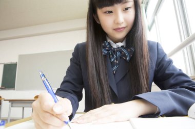 Güzel Japon genç kız sınıfta ders çalışıyor.