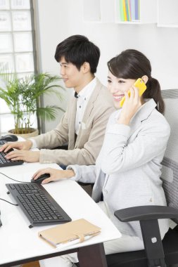 İş yerinde Asyalı iş kadınının akıllı telefonuyla konuştuğu portre. 