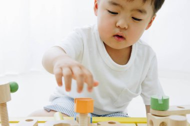 Küçük Asyalı çocuk oyuncaklarla oynuyor. 