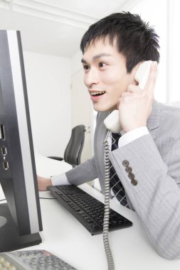 Ofiste telefonla konuşan genç Japon işadamının portresi