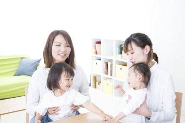 Masada oturan iki kadın ve çocuk.