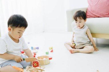 İki çocuk renkli tahta oyuncaklarla oynuyor.