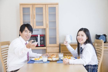 Gülümseyen baba ve kız kahvaltıyı evde yapıyorlar.