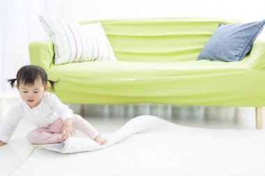 Asyalı çocuk evde yerde oynuyor. 