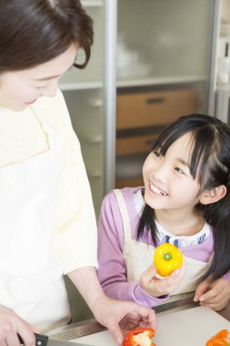 Asyalı kız anneme yemek pişirmesinde yardım ediyor.