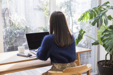 Kafede dizüstü bilgisayar kullanan güzel genç kadın