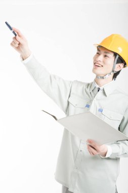 Beyaz arkaplanı gösteren Asyalı erkek mühendisin stüdyo portresi