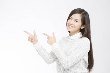 İşaret parmaklarıyla beyaz arka planda el kol hareketi yapan güzel bir Japon kadının stüdyo fotoğrafı. 