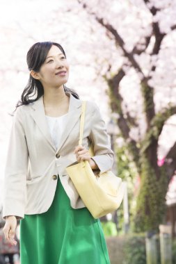 Güzel Asyalı kadın parkta yürüyor. 