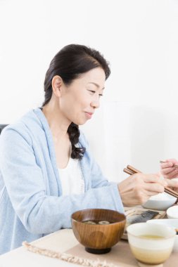 Evde pirinç yiyen Asyalı kadın.