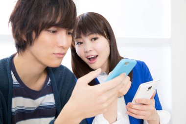 Genç çift cep telefonu kullanıyor, oyun oynuyor. 