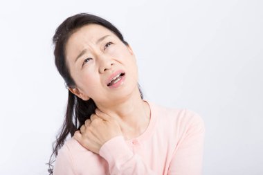 Boyun ağrısından muzdarip Asyalı kadın beyazın üzerinde izole edilmiş. 