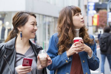 Sokakta kahve içen genç kadınlar 