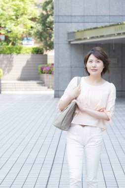 Genç Asyalı kadın şehirde yürüyor.