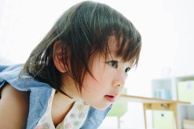 Küçük Asyalı kız gözlerini kaçırıyor.