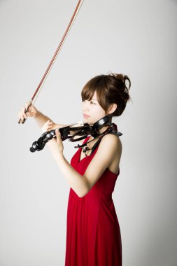 Genç Asyalı kadın keman çalıyor.