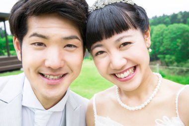 Parkta poz veren Asyalı gelin ve damat 