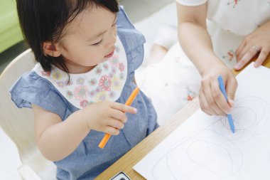 Annesiyle resim çizen tatlı Asyalı kız.