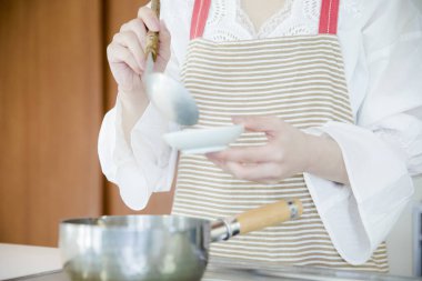 Mutfakta yemek pişiren bir kadının yakın plan fotoğrafı.