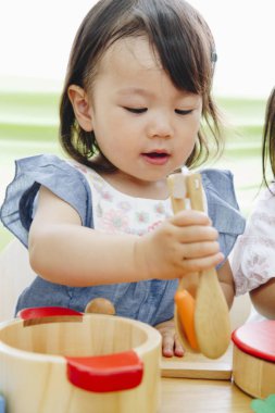 Evdeki oturma odasında oynayan tatlı Asyalı küçük kız.