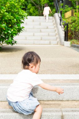 Genç Asyalı kız merdivenlerden çıkıyor. 