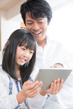 Evde tablet kullanan mutlu bir Asyalı aile.