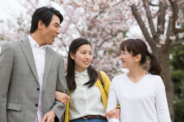 Asyalı olgun bir kadın. Kızı ve erkek arkadaşı parkta. 