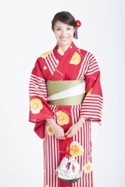 Geleneksel Japon kimonosu giyen güzel bir kadının portresi beyaz arka planda tek başına duruyor. 