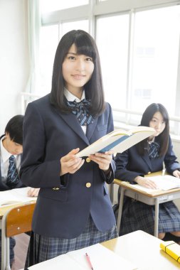 Genç Japon öğrenciler sınıfta okuyor.