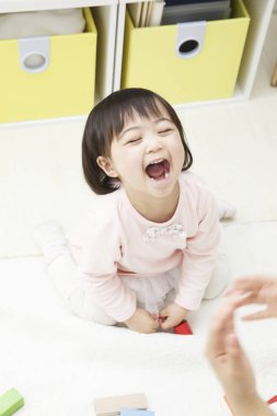 Anaokulunda oynayan Asyalı bebek.