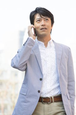 Asyalı işadamı cep telefonuyla konuşuyor