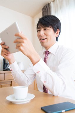 Genç işadamı sabah tablet kullanıyor.