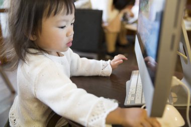 Masada bilgisayar kullanan genç bir kız.