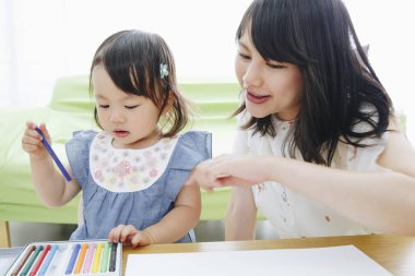Annesiyle resim çizen tatlı Asyalı kız.