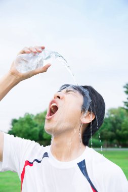 Koşu yaptıktan sonra kendine su döken genç bir adamın portresi.