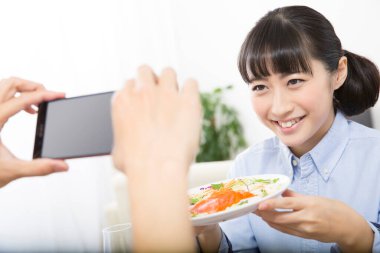 Kadının salatanın fotoğrafını çekerken yakın plan çekimi.