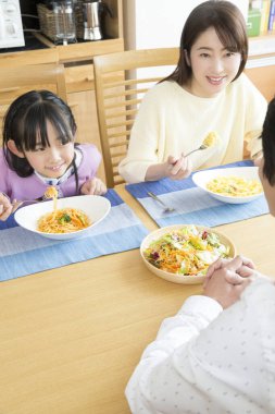 Mutlu bir aile mutfakta öğle yemeği yiyor.