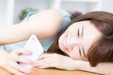 Cep telefonlu bir kadın evde selfie çekiyor. 